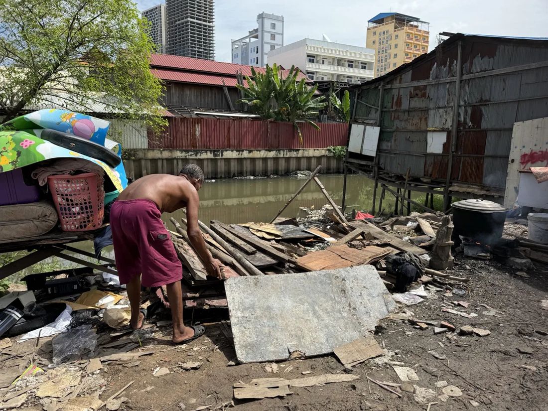 A canalside informal settlement in the shadow of new high-rise towers